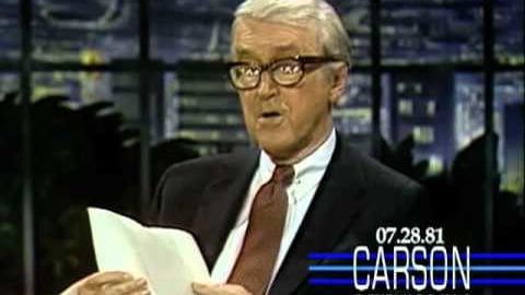 An older adult male in a dark suit jacket, white shirt, and red tie seated indoors at what appears to be a news desk; text on screen reads '07.28.81 CARSON'.
