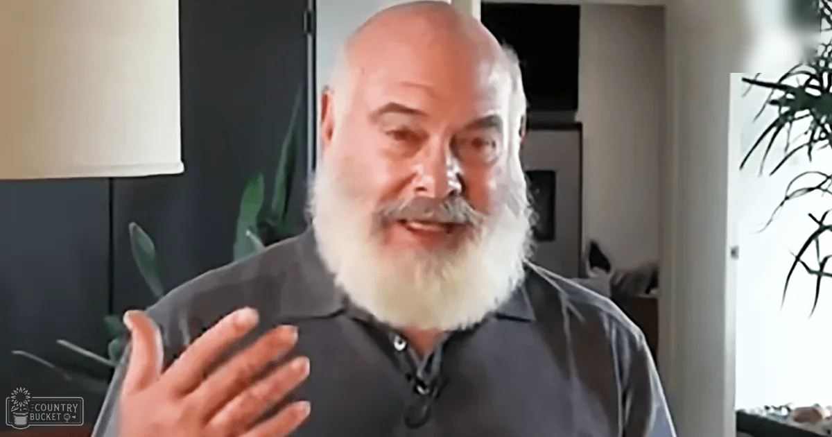 An older adult male in a home setting, wearing a dark gray collared shirt with short sleeves and a button-down collar.