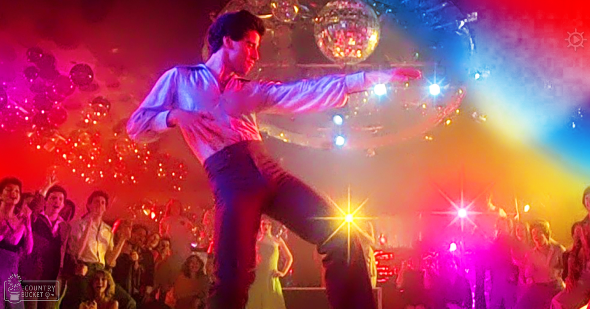 A man dancing in a vibrant, lively disco club with bright red and pink lighting during summer evening or night.