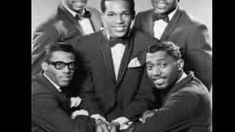 A group photo from the mid-20th century with three young adult males in formal attire against a plain indoor backdrop.
