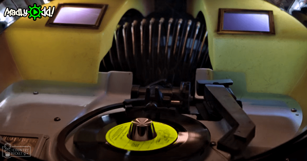 A vintage reel-to-reel tape recorder with a yellow label, set in an indoor studio or recording room environment.