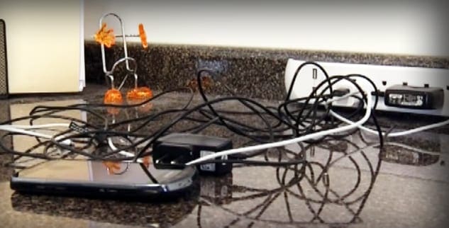 Tangled electrical cords on a granite countertop indoors