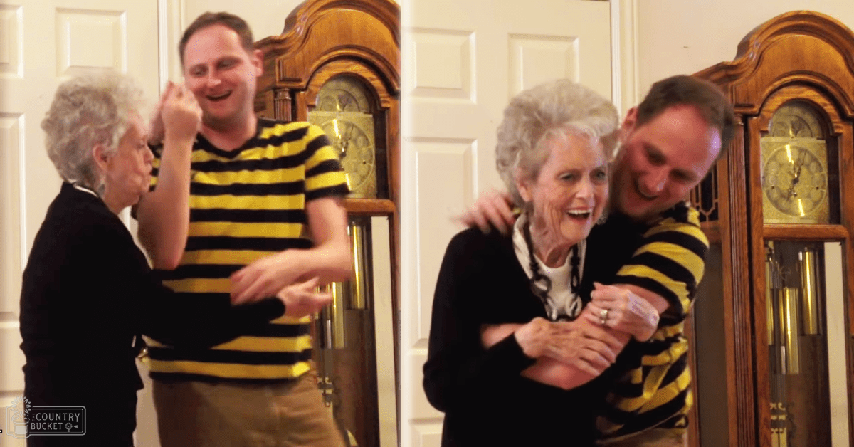 Two adults in a room with two grandfather clocks, one wearing a yellow and black striped shirt, another older adult female in a dark top; indoor setting, white doors visible, daytime lighting.