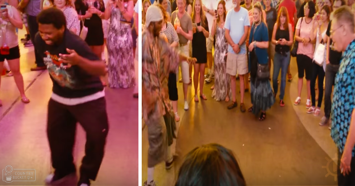 Adult male dancing indoors at a social event with warm ambient lighting.