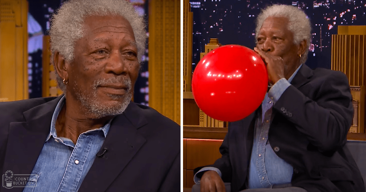 An older adult male singer wearing a dark blazer over a light blue denim shirt, holding a microphone in a studio setting with a red balloon and blurred cityscape background.
