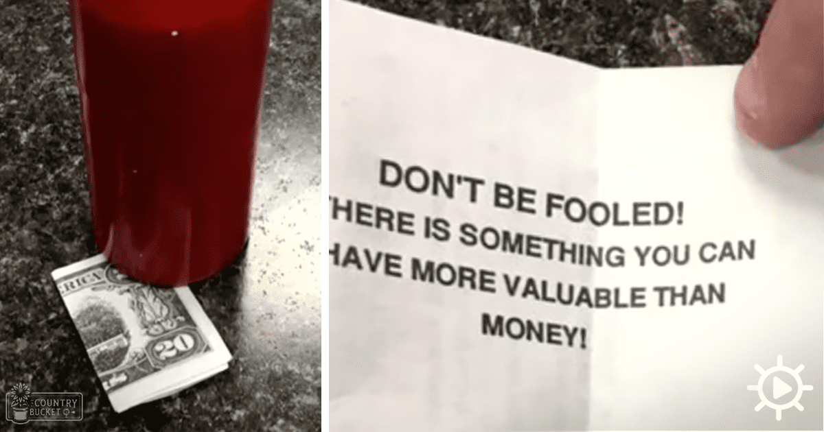 A motivational note about valuing something more valuable than money placed near a melted red candle partially covering a twenty-dollar bill on an indoor dark countertop or table with natural light.