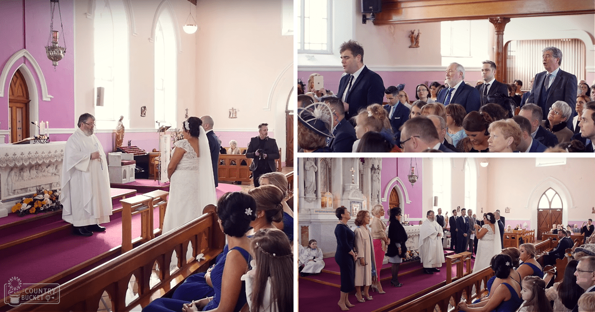A wedding ceremony unfolds within a church adorned with pink walls and floral arrangements; natural light streams through arched windows, illuminating guests in formal attire.