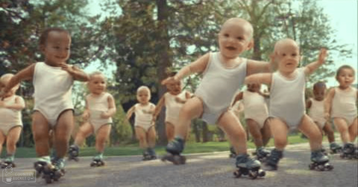 Infants rollerblading in a sunny outdoor park with green trees and grass, suggesting spring or summer season.