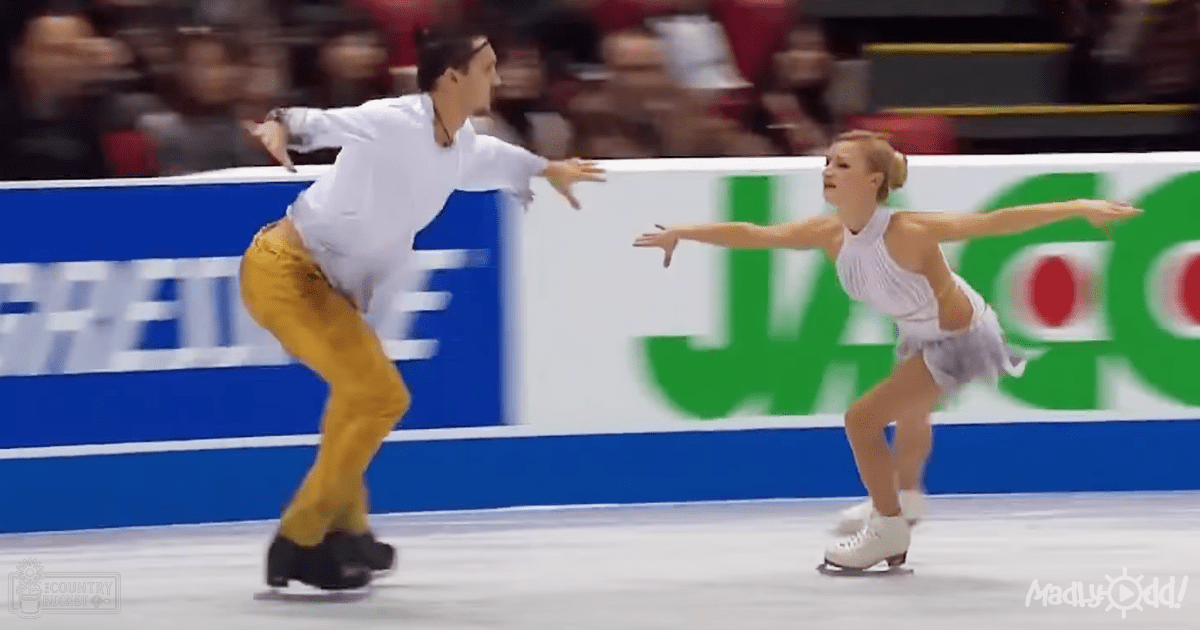 A male figure skater in an indoor arena wearing a white shirt, mustard-yellow textured pants, and black skate boots, paired with a female skater in a white sleeveless leotard-style top and white skate boots. The event appears to be a competition or exhibition held at a public ice skating rink under artificial lighting.