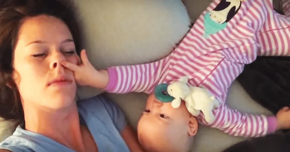 A young adult female with a toddler girl in an indoor setting, surrounded by soft furnishings and natural light.