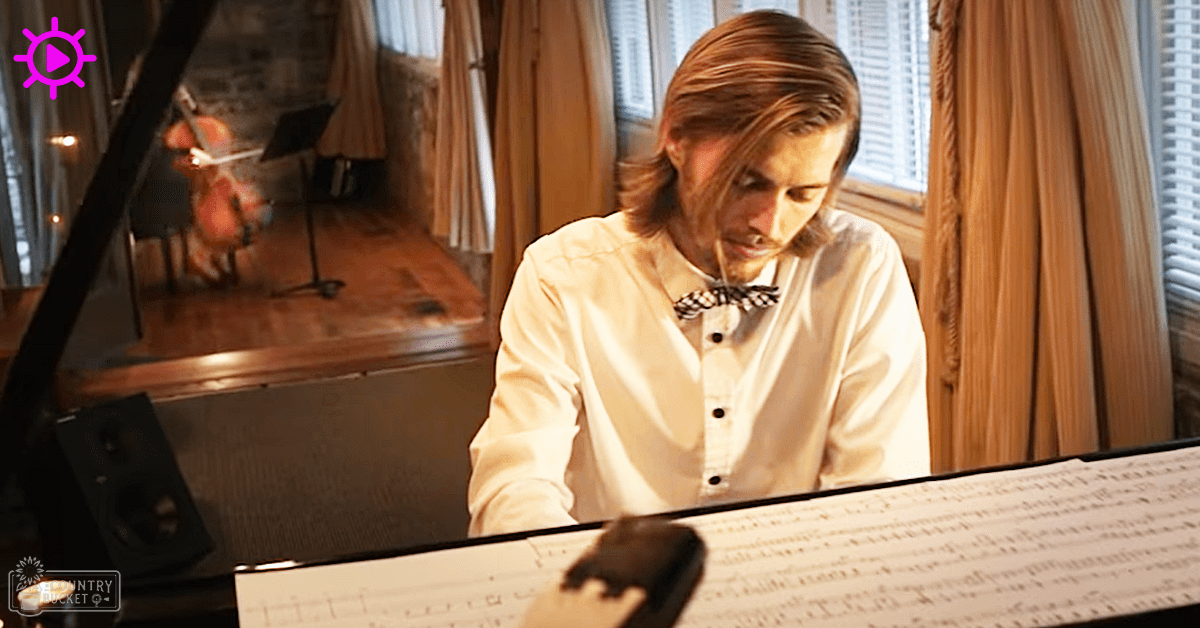 A young adult male plays piano in an indoor music studio with natural light and a checkered bow tie, surrounded by musical instruments and decor.