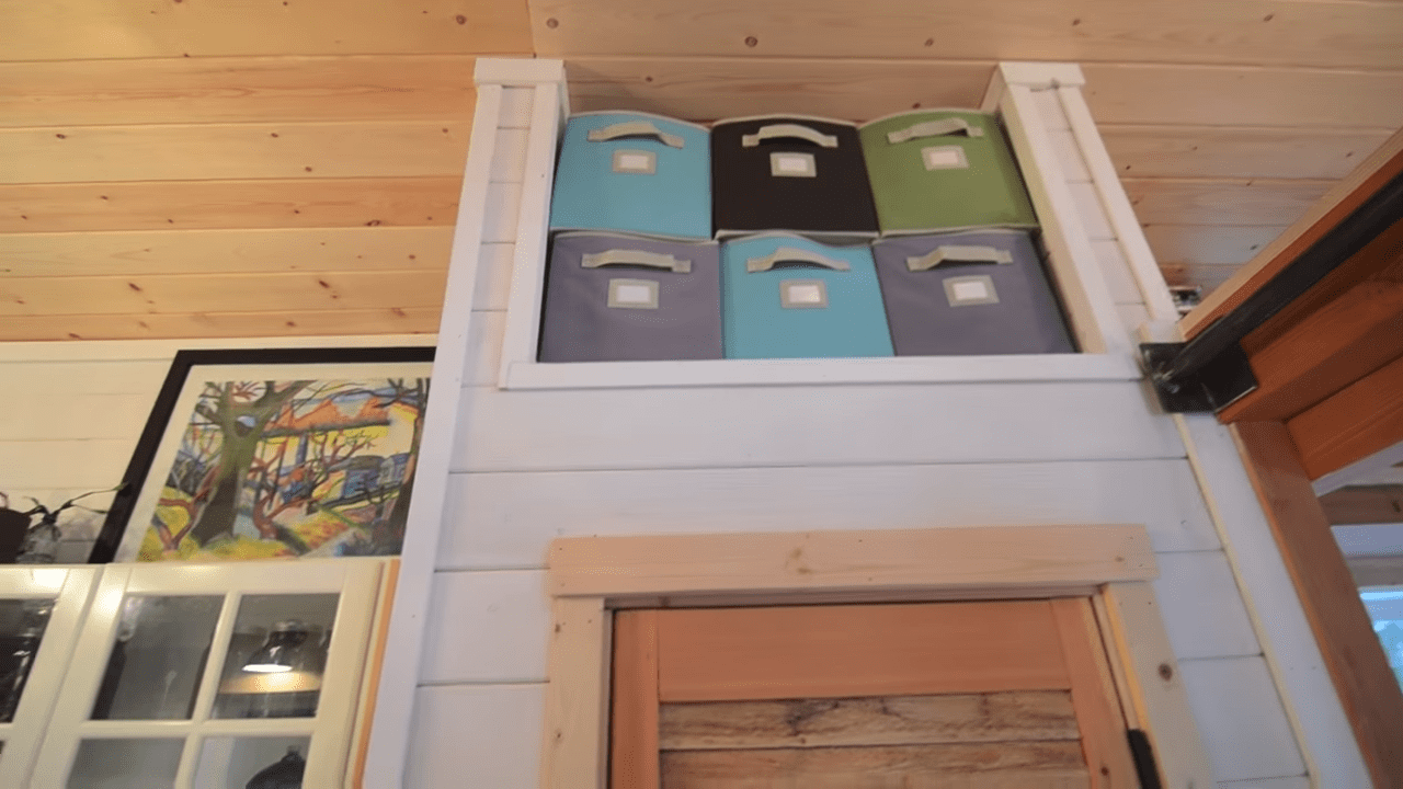 Fabric-covered storage bins in a cozy indoor space with wooden paneling and abstract art, natural light creating a warm ambiance.