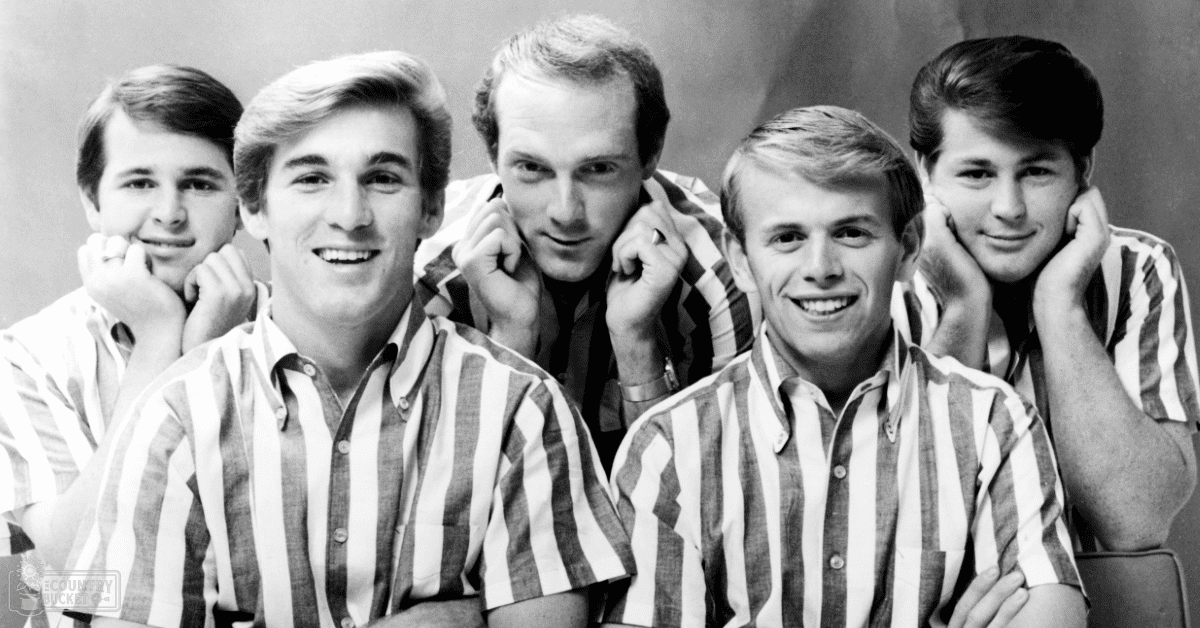 A group of young adult males wearing similar striped short-sleeved shirts in a studio setting with plain background lighting.