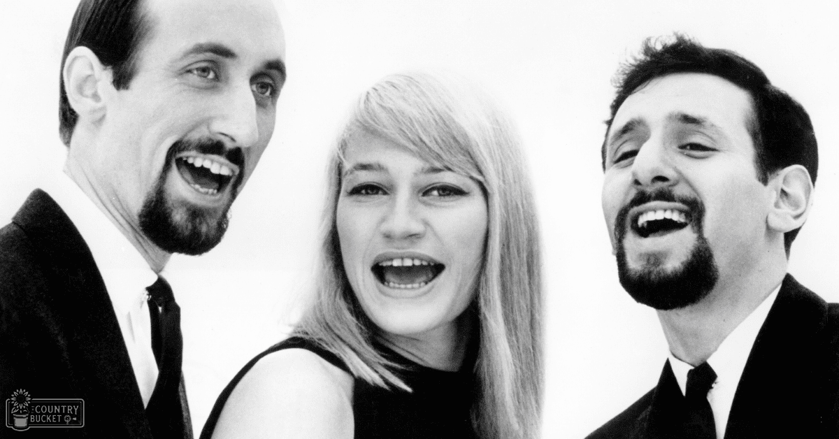 Three adults dressed formally, posed against a plain white background in an indoor setting with even frontal lighting.