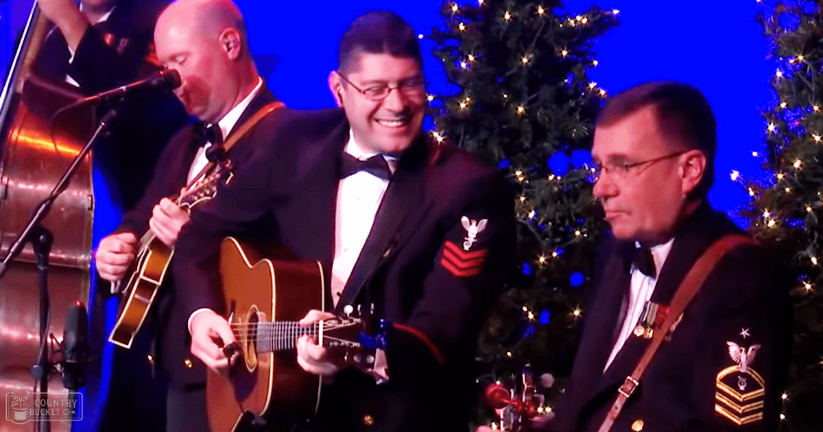 A musical performance in front of Christmas trees, likely at an event or gathering with performers dressed in formal military attire.