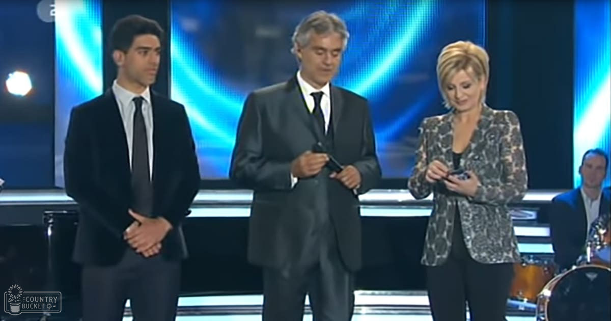 Adult males and a female dressed formally at what appears to be an awards ceremony, with dynamic blue lighting in the background suggesting a modern venue.