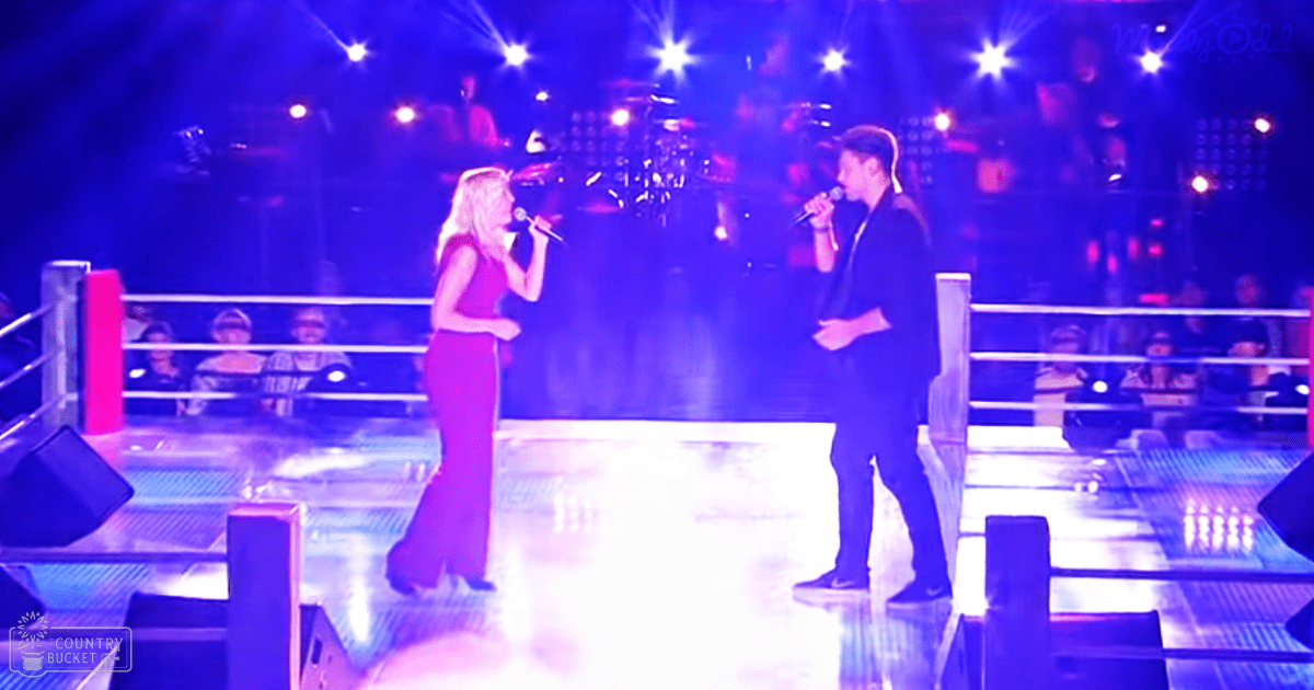 Indoor arena with a female singer in a red dress and male performer, audience seating visible.