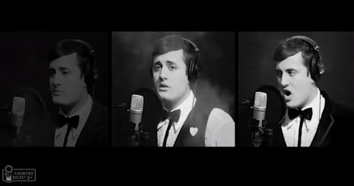 Young adult male singer wearing a black tuxedo, white shirt, and black bow tie in a recording studio setting.