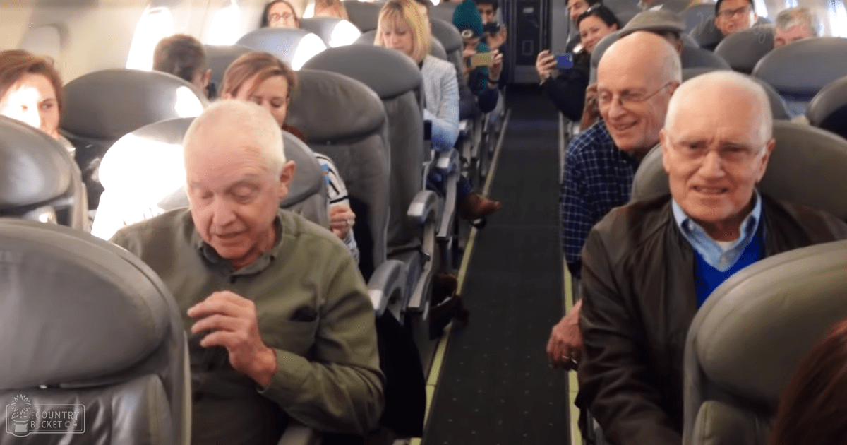 Inside an airplane cabin with rows of seats and passengers seated during flight.