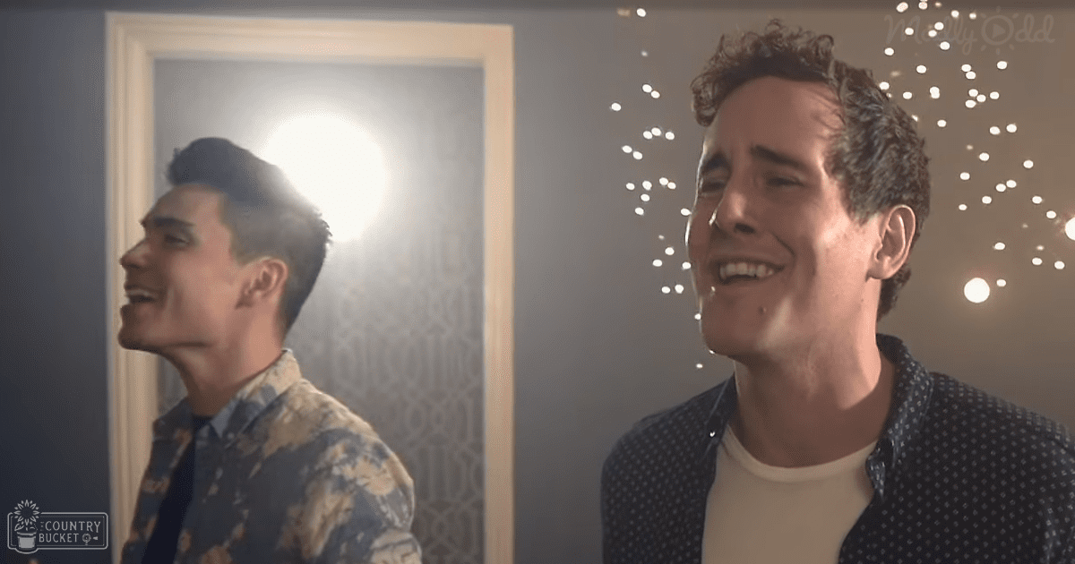 Young adult male in a patterned shirt indoors with string lights adding ambiance to the scene.