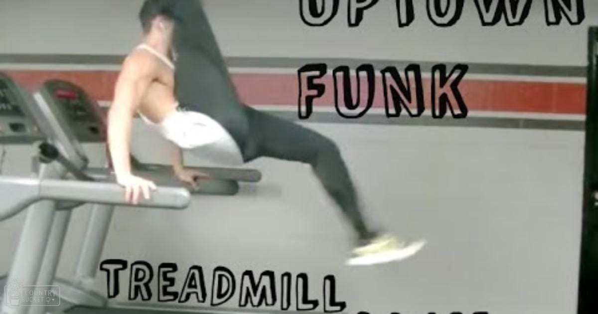 Young adult male wearing white tank top with thin straps, gray athletic pants, and white sneakers in an indoor gym setting with 'UPTOWN FUNK' and 'TREADMILL' text on the wall.