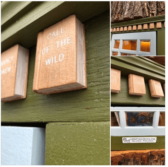 Decorative wooden book-like structures mounted on a green-painted wall in an outdoor setting with tree bark and part of a window frame visible.