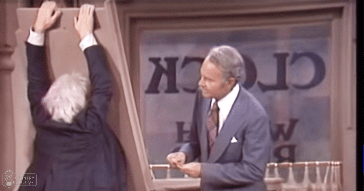An older adult male in a dark suit interacts with another middle-aged man at an ATM machine, wearing a light blue suit and paisley-patterned tie.