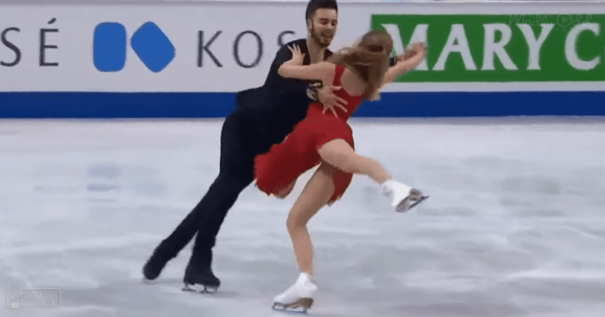 A figure skating pair performing in an indoor ice rink with a banner displaying 'KOSÉ' and another partially visible sign indicating sponsorship.