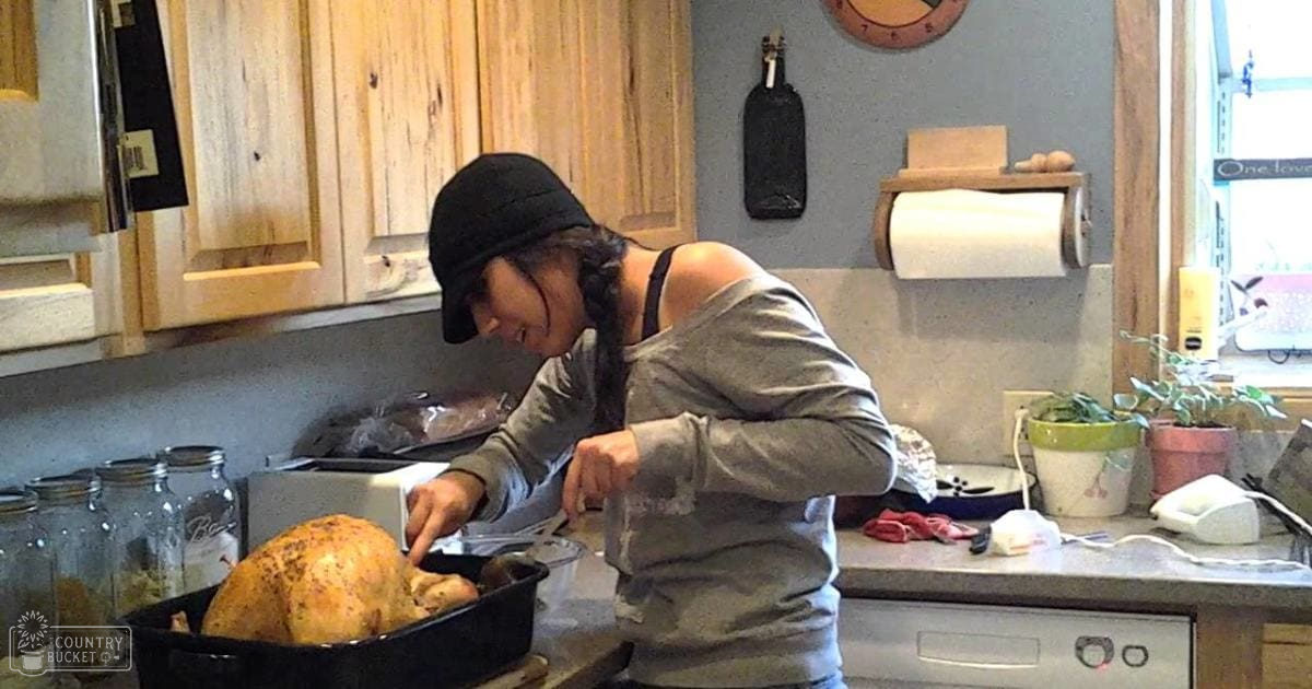 A young adult female prepares food in a kitchen with natural light streaming through the window.