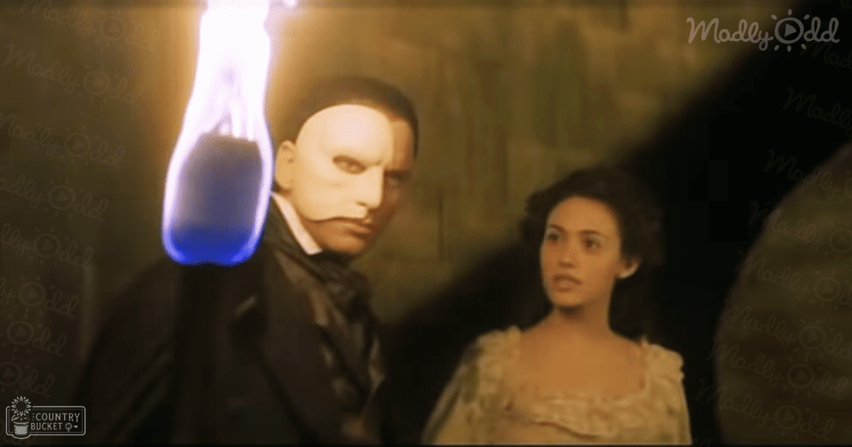 A Victorian-era male character in a formal black suit stands beside a female character wearing a white lace dress with ruffled details, set within an opera house at night.