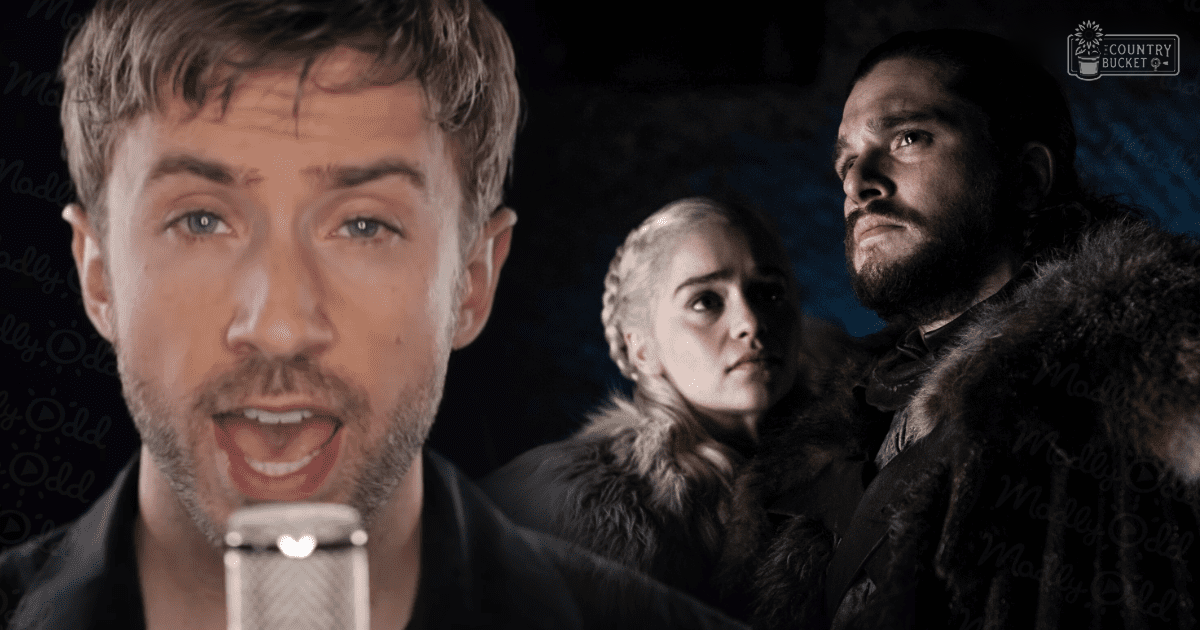 An adult male singer in front of a scene from 'Game of Thrones' set indoors with dim lighting and dark tones, typical of nighttime scenes.
