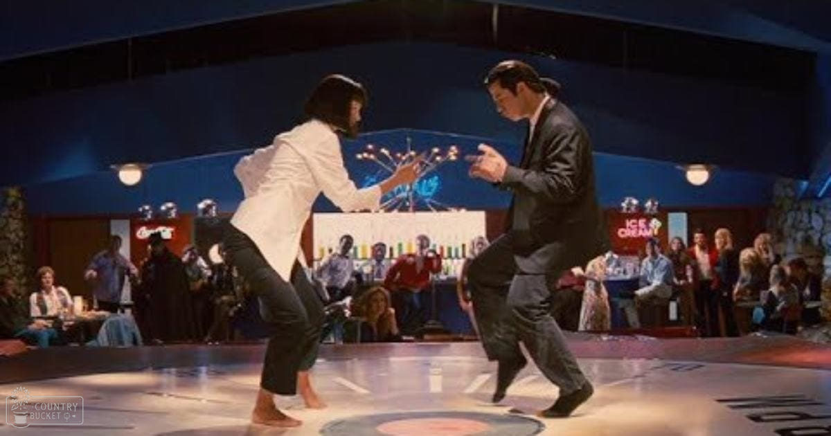 A vibrant dance scene in a disco setting with young adult dancers barefoot on stage and casual adults seated at tables in the background.