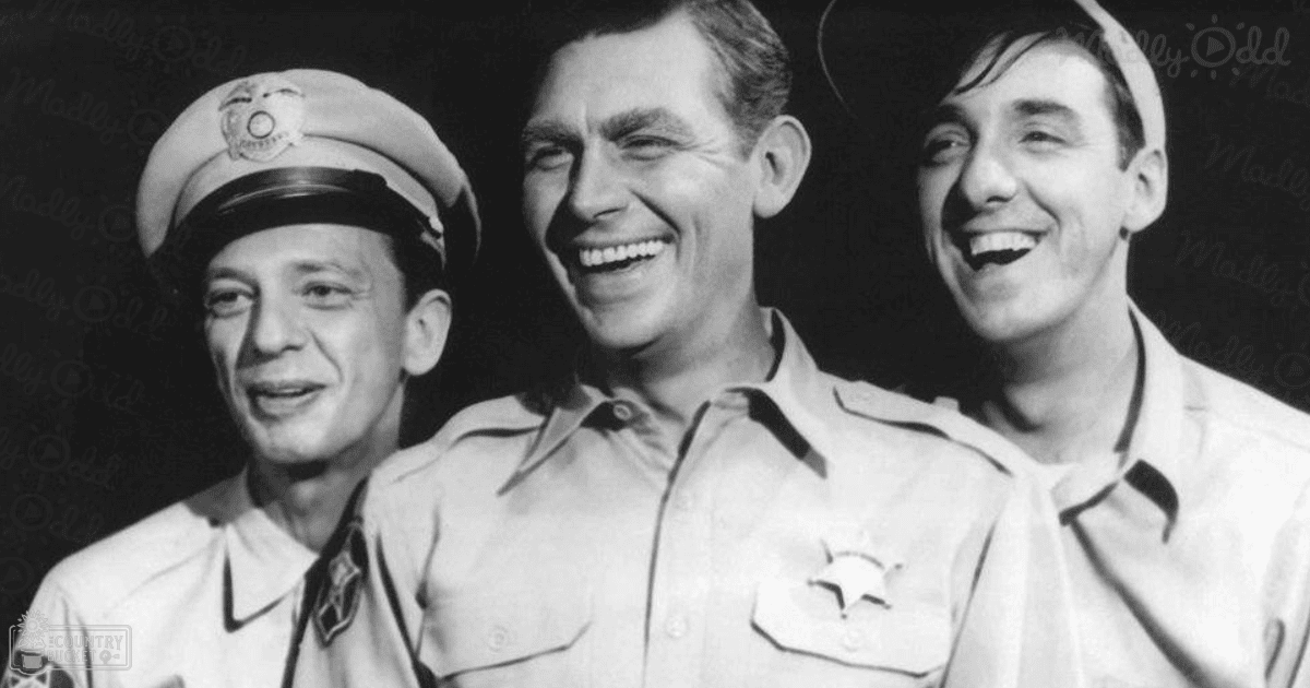 Three adult males dressed in mid-20th century attire stand side by side against a dark studio backdrop.