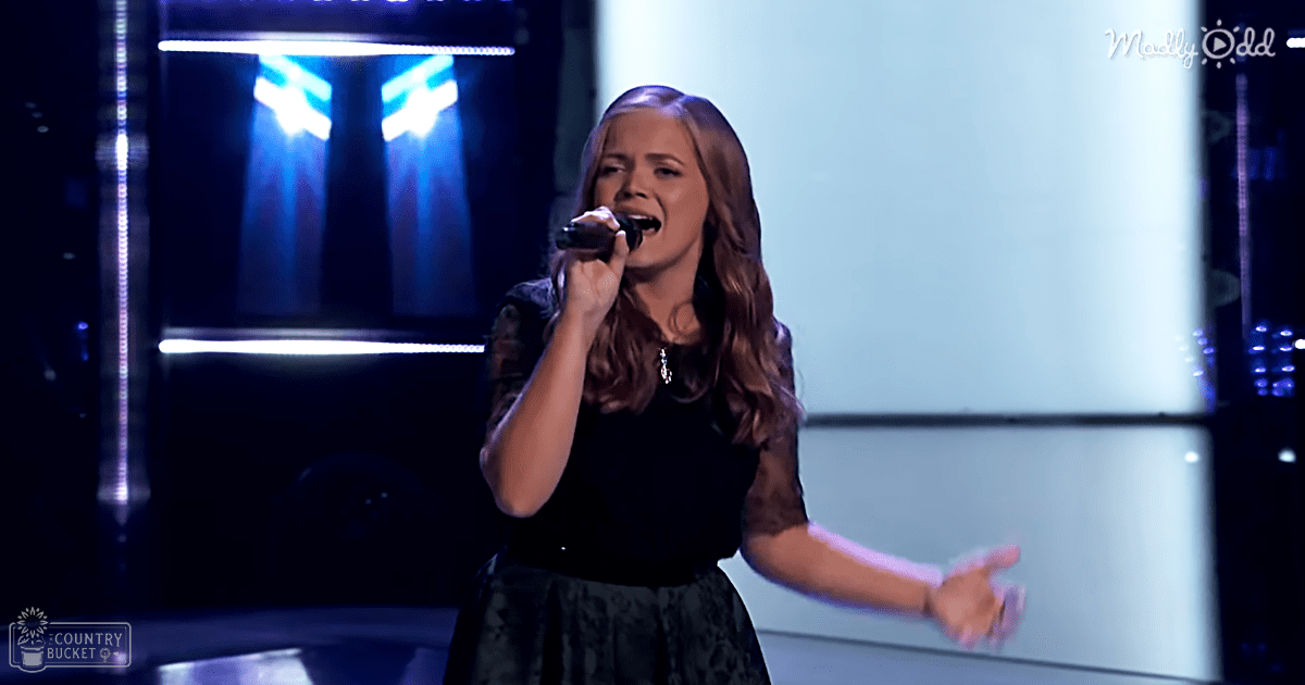 A young adult female performer singing on a stage in an entertainment venue, wearing a black lace-trimmed dress with modern fashion style.
