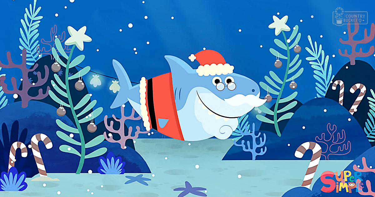A cartoon shark wearing a Santa hat swims underwater among festive decorations including ornaments resembling Christmas tree baubles, candy canes, and starfish. The scene is bright with marine life elements suggesting it's during the holiday season.