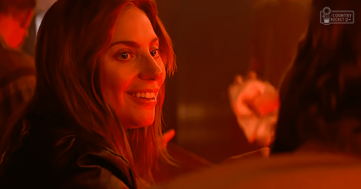 Young adult female in a dimly lit indoor environment with warm reddish lighting.