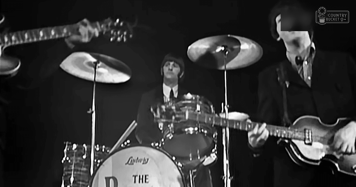 Musical performance scene with adult male musicians in dark suits and white shirts, microphone, indoor stage setting, black and white dominant colors.