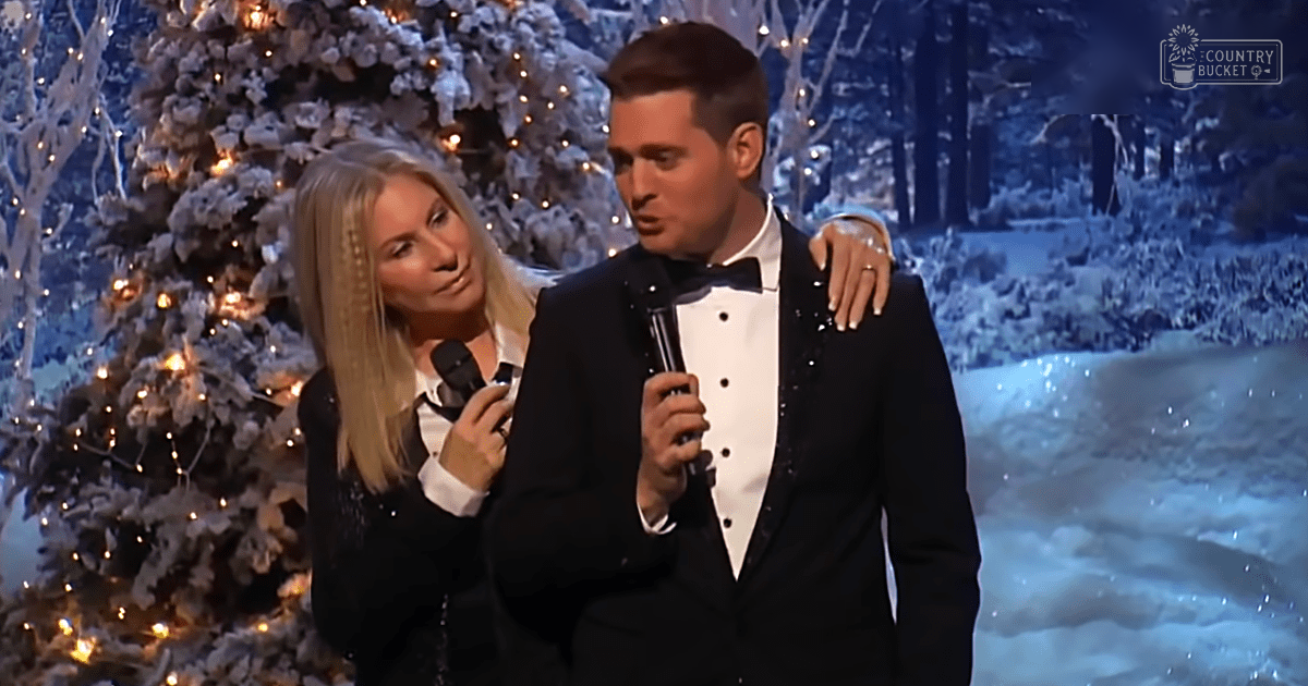 A couple performing at a festive indoor event, possibly during Christmas time; woman in black tuxedo-style dress, man in classic tuxedo with white shirt and bow tie.