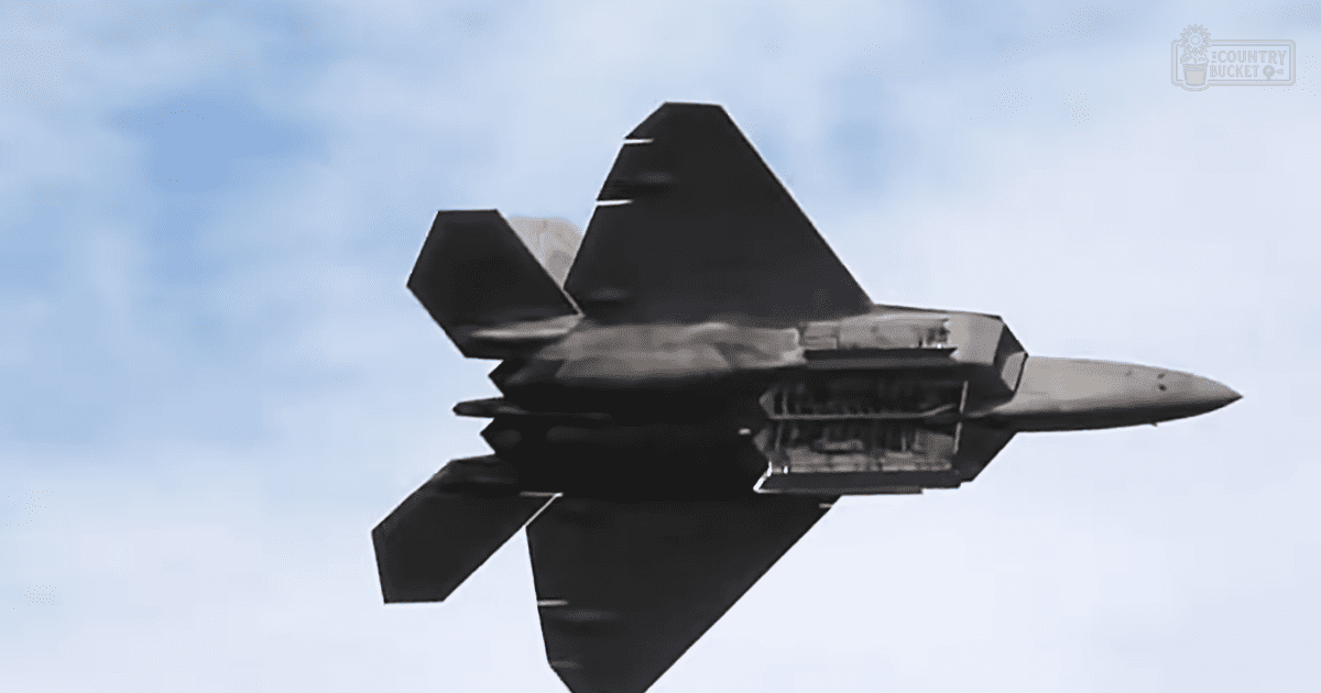 A clear sky with a fighter jet flying outdoors in daylight, dominated by shades of blue and black.