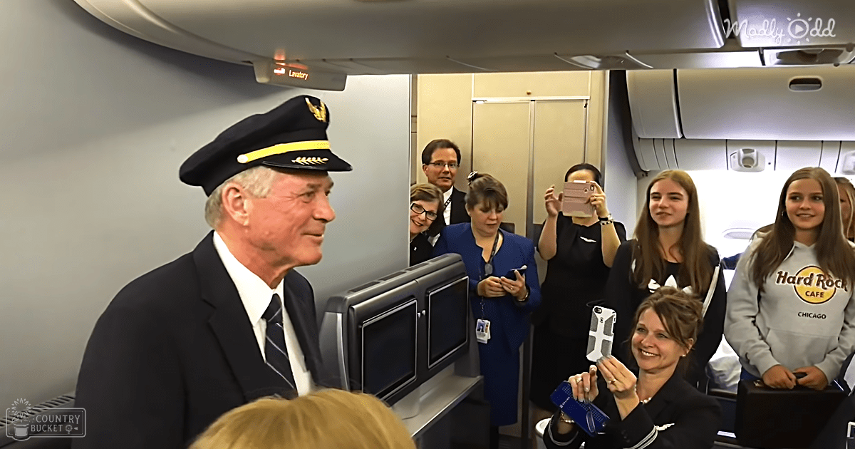 Passengers inside an airplane cockpit, wearing dark blue uniforms and interacting with smartphones in a daytime setting.