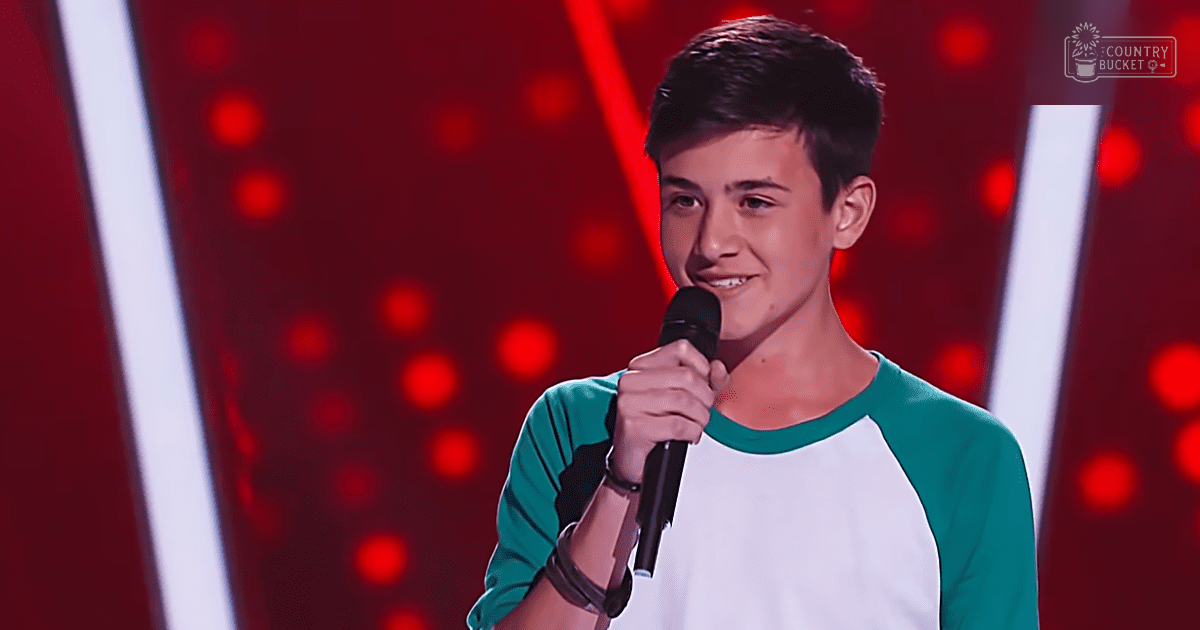 Young adult male in a modern casual green and white raglan-sleeve t-shirt with black wristband, performing on stage at a talent show under red and white vertical light bars.