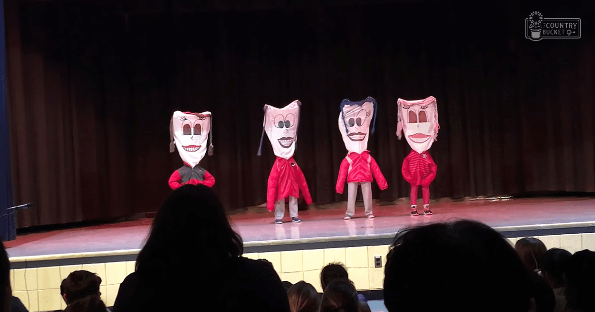 Children performing a theatrical play on stage at an indoor venue