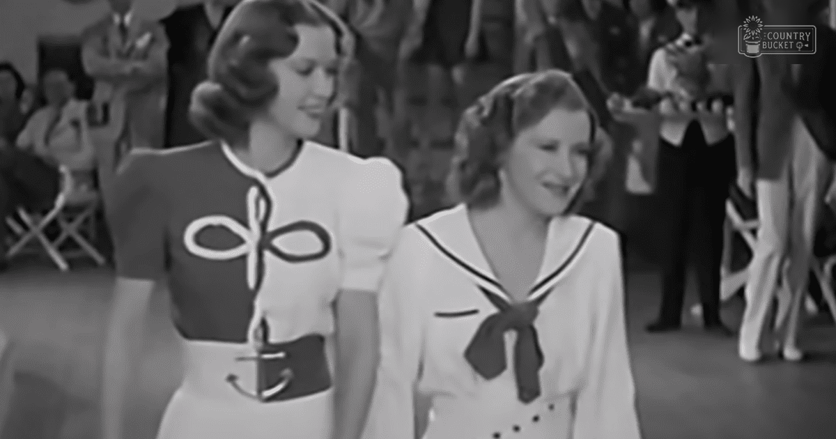 Two women wearing nautical-themed clothing in an indoor social setting with chairs visible in the background.