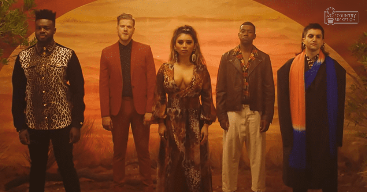 Group photo of adults in a desert-themed indoor studio with warm lighting and orange hues dominating the scene.