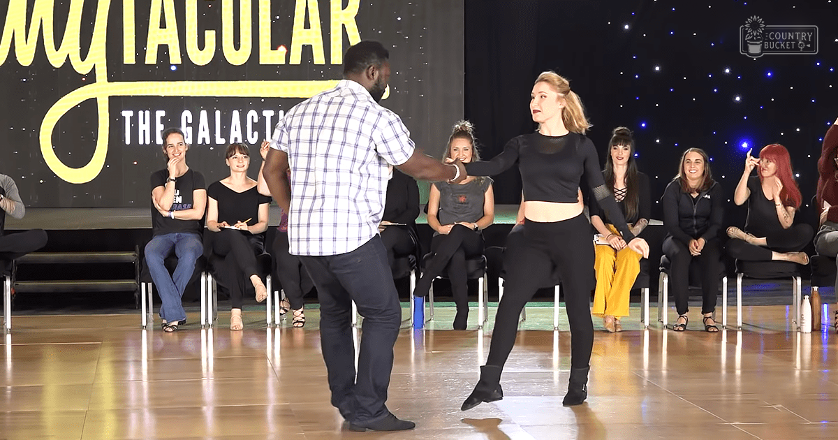 A dance performance at a studio or event space with participants in various settings and attire, including a man leading and a woman dancing.