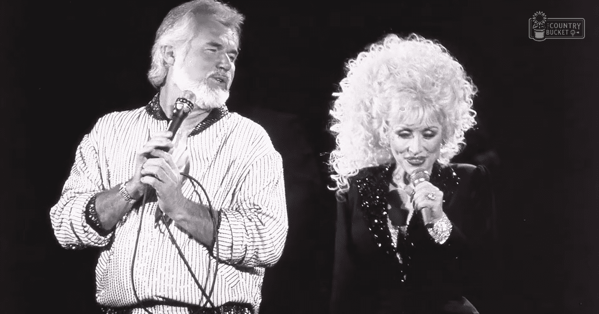 Musical performance scene with two individuals; older adult male singer in a striped, textured shirt and female singer in a dark sequined dress, both holding microphones on stage under dim lighting.