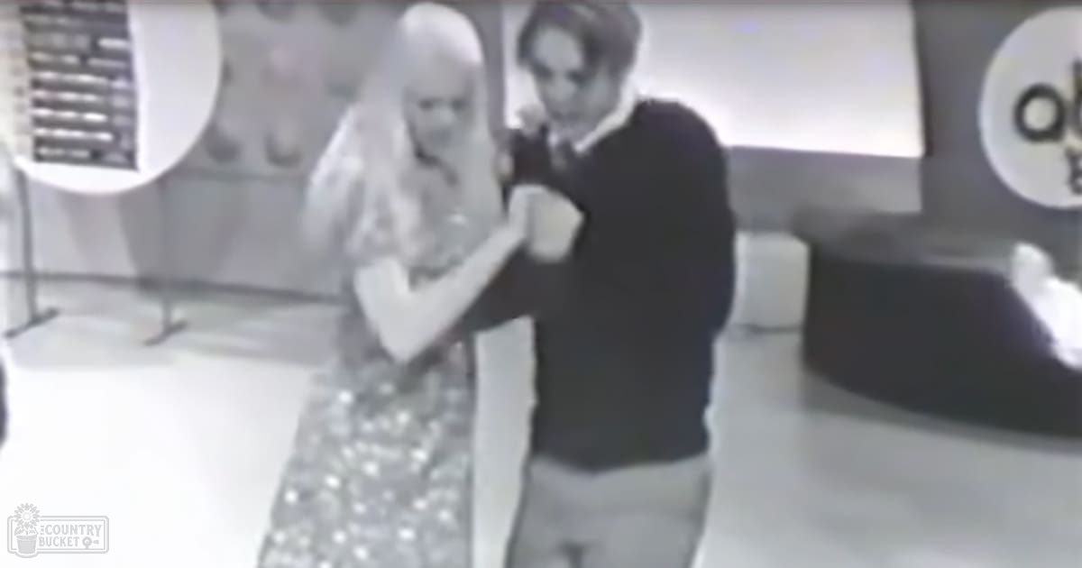 An adult male proposing marriage to an ice sculpture at a themed indoor event with artificial lighting and large decorative elements.