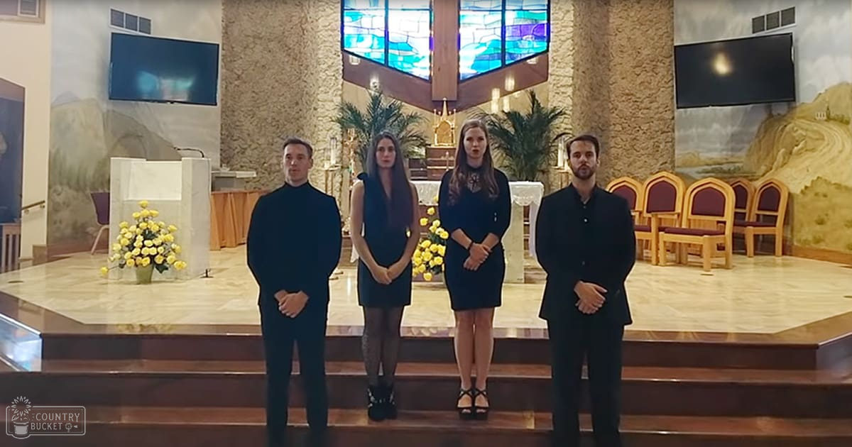 Four individuals in a church setting with stained glass windows and wooden chairs; natural light illuminates the interior.