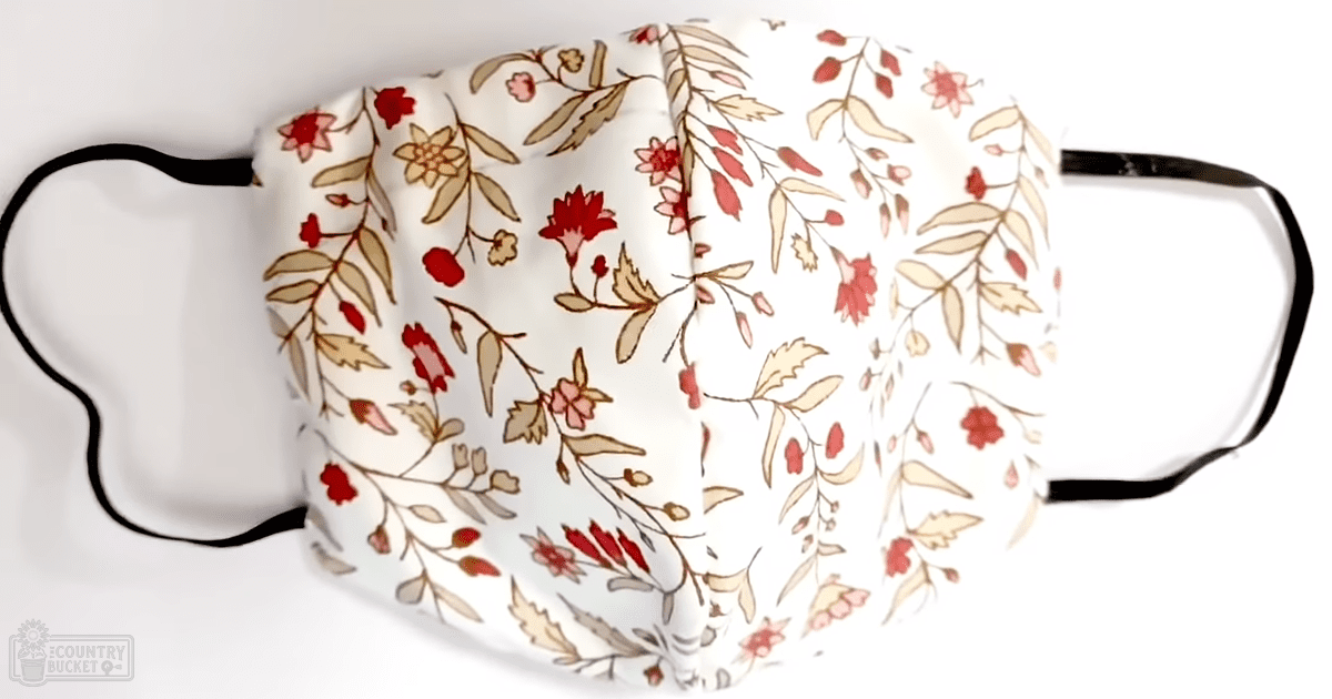 A fabric face mask with floral patterns in an indoor setting.