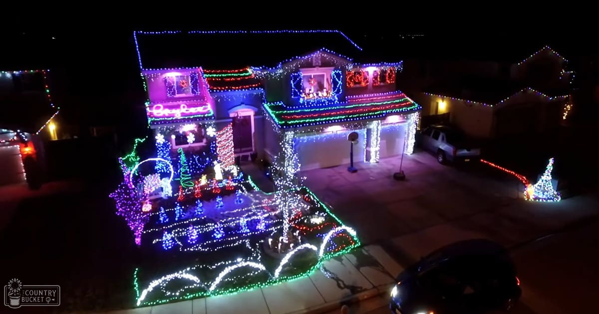 A house adorned with colorful Christmas lights in an urban residential area at night